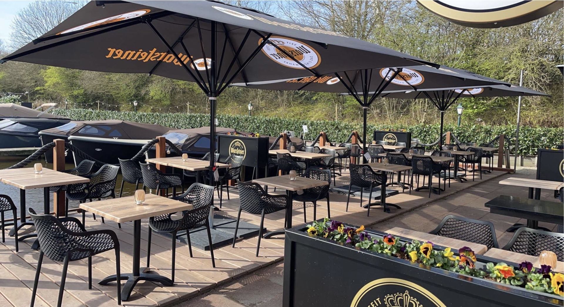 Terras van restaurant BREEZE met uitzicht op de jachthaven bij zonsondergang